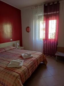 a bedroom with a bed with two towels on it at B&B Casa Mia in Alghero