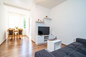 ein Wohnzimmer mit einem Sofa, einem TV und einem Tisch in der Unterkunft Apartment Joky in Dubrovnik