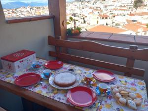 a table with plates of food and a view of a city at AFFITTACAMERE DORGALI B&B da ZIETTO in Dorgali