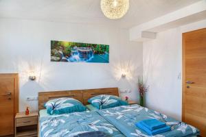 a bed with blue pillows in a bedroom at Fewo Bergtroll in Uderns