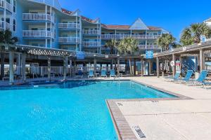 a swimming pool in front of a large apartment building at Charming Beachside Condo Lovely Pool Hot Tubs and Boardwalk in Galveston