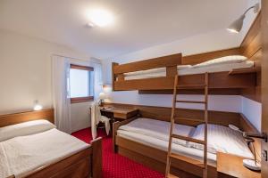 a bedroom with two bunk beds and a desk at Haus Sonnbichl in Weissensee