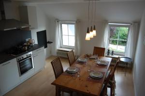 een keuken en eetkamer met een houten tafel met stoelen bij Ferienwohnung im Gulfhof in Krummhörn