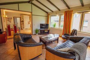 a living room with two couches and a coffee table at Zur alten Mühle in Krummhörn