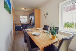 una sala da pranzo con tavolo e sedie in legno di Haus Leuchtturm - Ebbe a Krummhörn