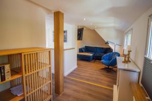 ein Wohnzimmer mit einer Treppe und einem blauen Sofa in der Unterkunft Wolke 7 - Mond in Greetsiel