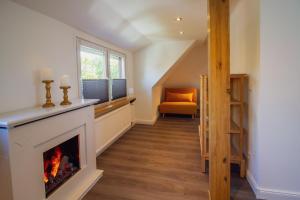 a living room with a fireplace and an orange chair at Wolke 7 - Mond in Greetsiel