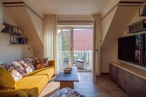 a living room with a couch and a television at Up Besöök - Rapsblüte mit Infrarotsauna in Krummhörn