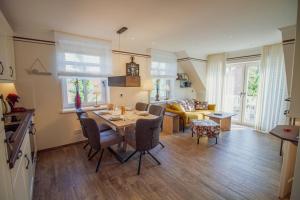 a kitchen and living room with a table and chairs at Up Besöök - Rapsblüte mit Infrarotsauna in Krummhörn