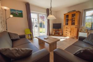 a living room with two couches and a coffee table at Haus Leuchtturm - Flut in Krummhörn