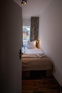 un piccolo letto in una camera con finestra di Das Posthaus - Amt a Greetsiel
