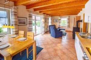 Una cocina y una sala de estar con mesa y sillas. en Haus Merlin - Silbermöwe, en Greetsiel