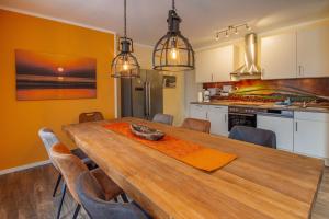 uma cozinha e sala de jantar com uma mesa de madeira e cadeiras em Huus Viskert em Krummhörn