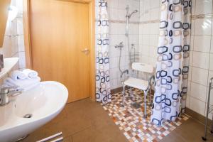 uma casa de banho com um WC, um lavatório e um chuveiro em Haus Merlin - Silbermöwe em Greetsiel