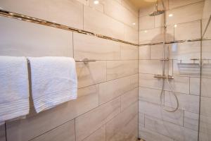 a bathroom with a shower with white tiles at Huus Viskert in Krummhörn +22 photos