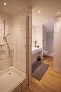 a bathroom with a shower and a tub and a toilet at Architektenhaus am Pewsumer Tief in Krummhörn