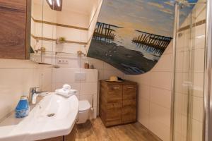 a bathroom with a sink and a toilet and a shower at Up Besöök - Wildrose mit Sauna in Krummhörn
