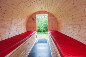 a red brick building with a red wall at BCC Lochness Glamping in Bearnock