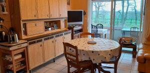 eine Küche mit einem Tisch und einem Esszimmer in der Unterkunft ferme équestre des abrons in Pailloles
