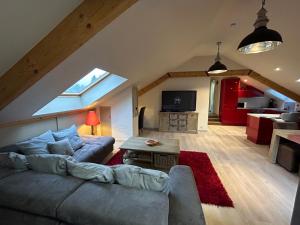 a living room with a couch and a table at Race & Rooms Appartment in Stavelot