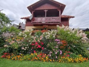 a flower garden in front of a house with a balcony at Szarotka Pienińska in Szczawnica