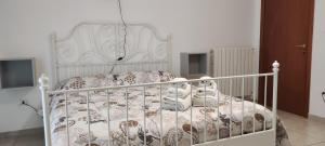 ein Schlafzimmer mit einem weißen Bett mit einem weißen Kinderbett in der Unterkunft DA VINCI AFFITTACAMERE BORGO in Taranto