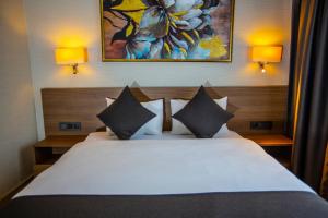 a bedroom with a white bed with two pillows at Istanbul Park Hotel in Tuzla