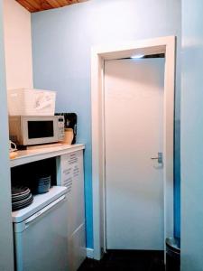 a door to a kitchen with a microwave on a counter at aabAlree Guest House in Dundee