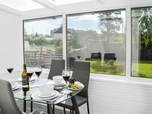 a table with glasses of wine and a plate of food at The Bungalow in Borgue