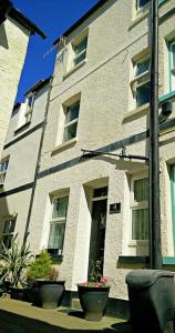 un edificio con vasi di fiori di fronte di Birds Nest Cottage Looe a Looe