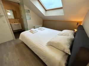 una camera da letto con un grande letto bianco e un lucernario di Race & Rooms Appartment a Stavelot