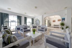 a waiting room with blue couches and a table at HOTEL MOHITERO in Kamari