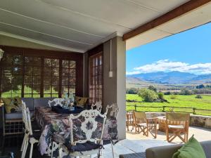 a dining room with a table and chairs on a patio at Silo Cottage in Underberg