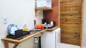 a small kitchen with a counter and a refrigerator at Pousada da Ferrugem - Praia da Ferrugem in Garopaba