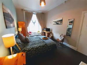 Schlafzimmer mit einem Bett, einem Schreibtisch und einem Fenster in der Unterkunft aabAlree Guest House in Dundee