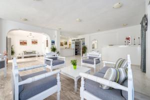 een woonkamer met blauwe stoelen en een tafel bij HOTEL MOHITERO in Kamari