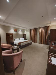 a hotel room with a bed and a couch and chairs at فندق تـاج النخبة - Taj Nakhba Hotel in Jazan
