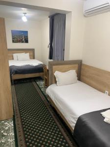 a room with two beds and a window at Hotel Oazis in Haskovo