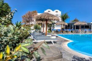 ein Pool in einem Resort mit Liegestühlen und Sonnenschirmen in der Unterkunft HOTEL MOHITERO in Kamari