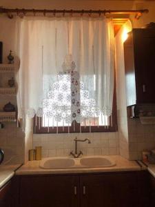 bagno con lavandino e finestra di Rita' s House Glossa Skopelos a Glossa