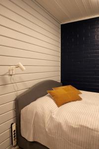 1 dormitorio con 1 cama con pared negra en Yllästokka 10 en Ylläsjärvi