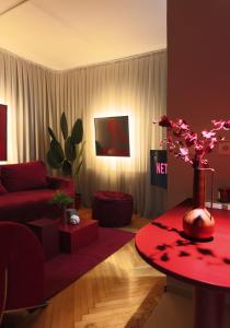 a living room with a red couch and a red table at Etern Stays - Maroon Apartment in Pristina