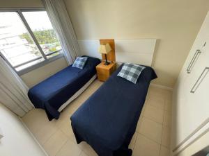 2 camas en una habitación pequeña con ventana en Apartamento Punta del Este, en Punta del Este