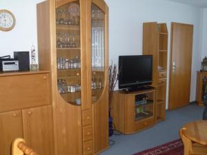 sala de estar con TV y armario de madera en Haus Seestern, en Büsum
