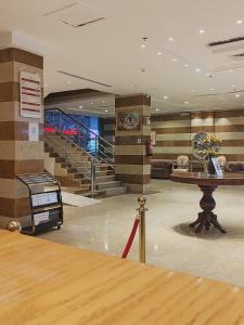 a lobby with a table and stairs in a building at فندق تـاج النخبة - Taj Nakhba Hotel in Jazan
