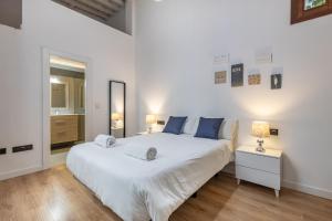 Un dormitorio con una gran cama blanca y una ventana en Apartamentos Granada Deluxe 3000, en Granada