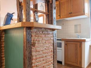 a kitchen with a brick wall next to a sink at Apartment Passage de l'escalier by Interhome in Ciboure