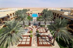 an overhead view of a resort with palm trees and a pool at Tilal Liwa Desert Retreat in Madīnat Zāyid