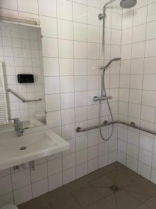 uma casa de banho com um chuveiro e um lavatório. em Hôtel et Cottages Domaine Du Marquenterre em Saint-Quentin-en-Tourmont