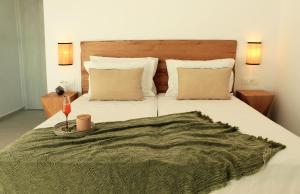 a bedroom with a large bed with a green blanket at Calistus Mykonos in Mikonos